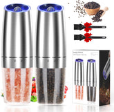 Electric salt and pepper grinder set with blue LED light illuminating spices being ground on dinner table
