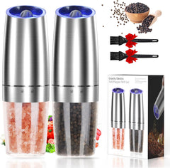 Electric salt and pepper grinder set with blue LED light illuminating spices being ground on dinner table